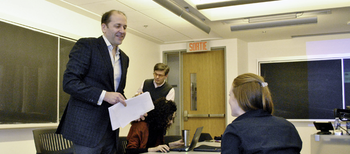 Marc Barbeau chats with a student in his business law class.