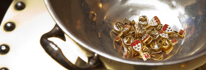 Silver metal bowl containing Scarlet Key pins.