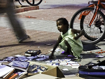 Black child with books on the street in Tel Aviv