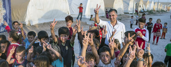 Photo of Payam Akhavan with refugee children (by Peter Bregg)