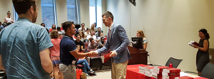 Dean Robert Leckey handing out copies of the latest Civil Law Code to new students as part of the Welcome Day activities.