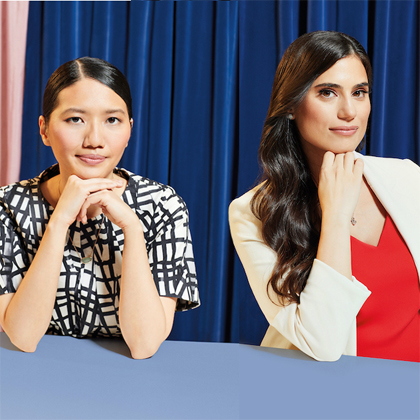 Cindy Kou and Dina Awad, photographed in a studio using a blue curtain backdrop