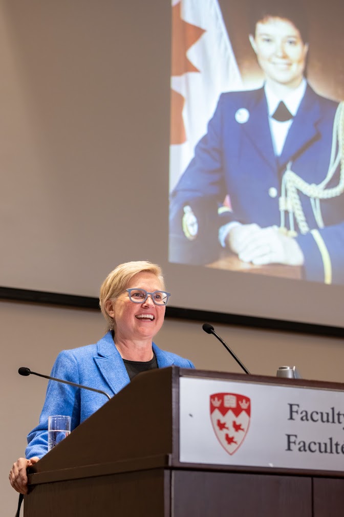 Michelle Douglas in front of a photo of her in army uniform