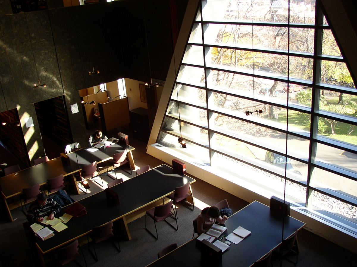 Students studying at tables by the window of the Nahum Gelber Law library